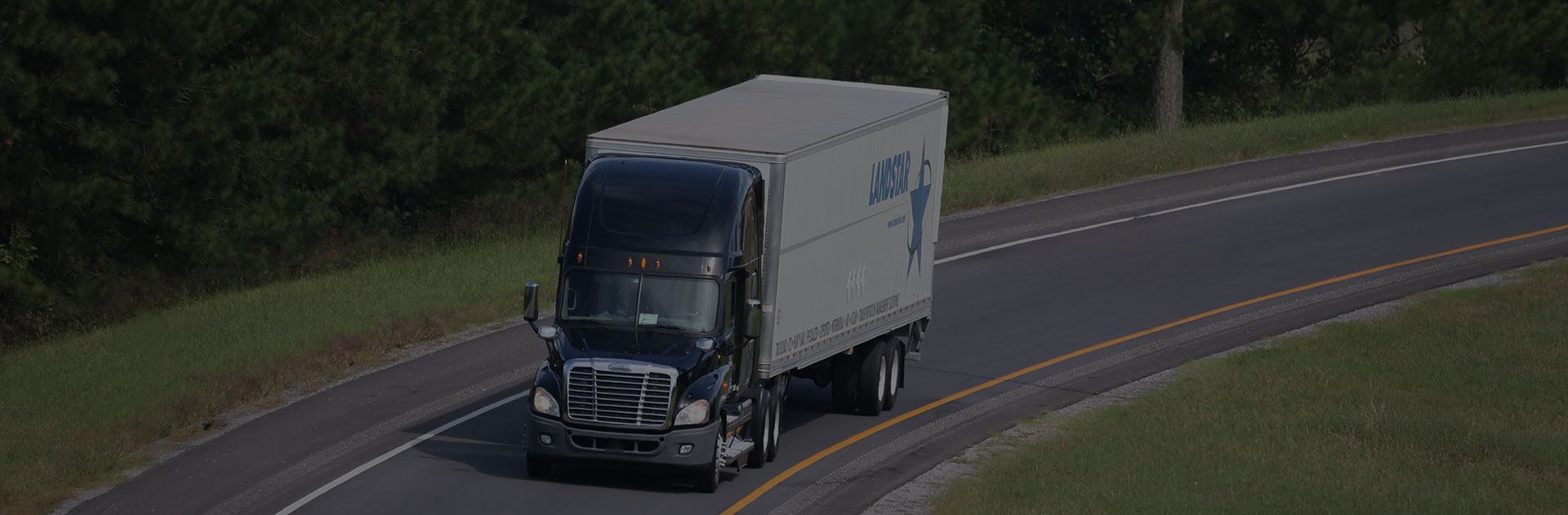 A Landstar truck moving down the highway, carrying its shipments to their destination.